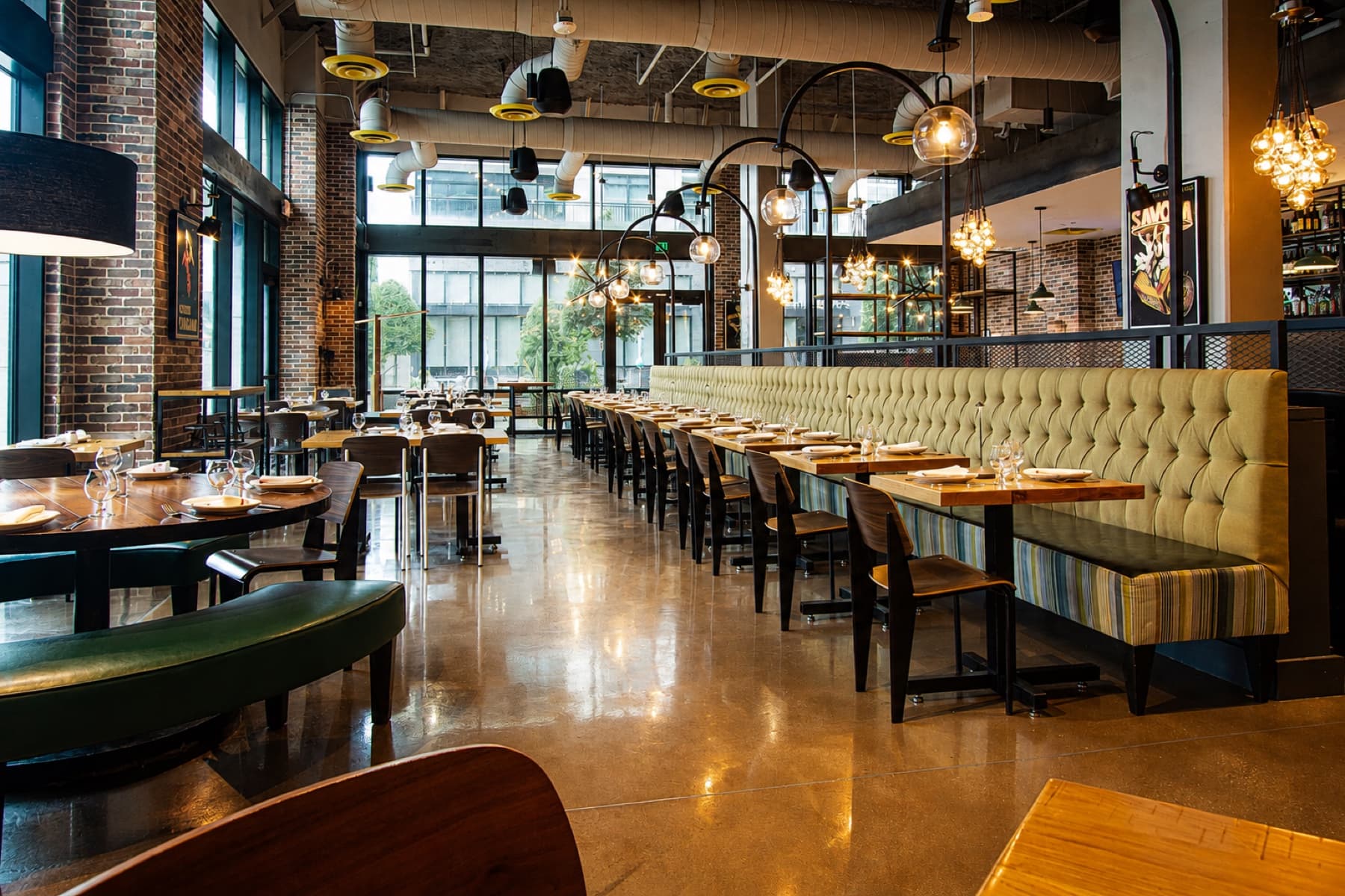 Sunlight across the olive banquettes and set tables at Anthonys New York Italian in River Oaks, Houston