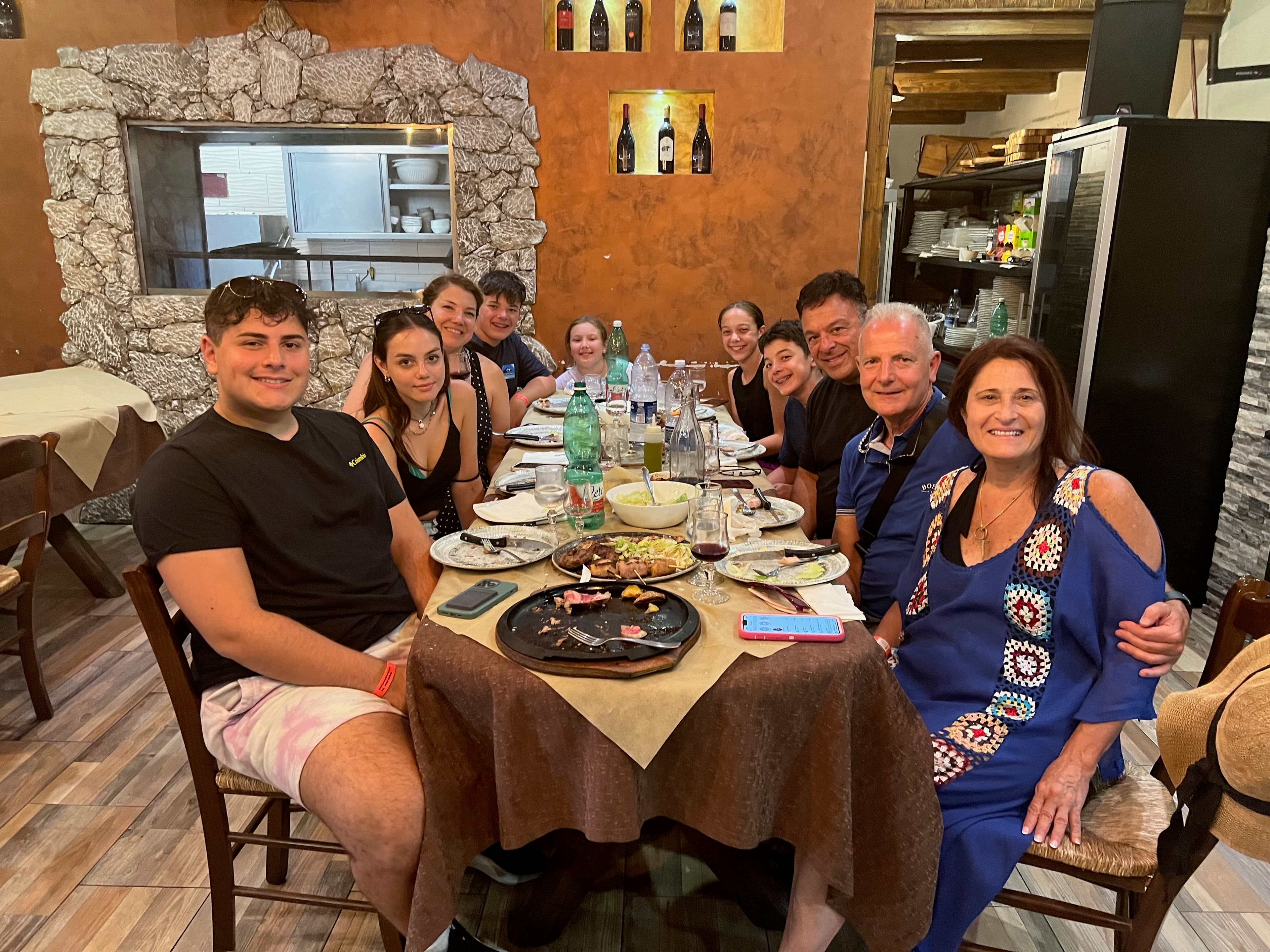 The Russo family gathered around a dinner table in Italy